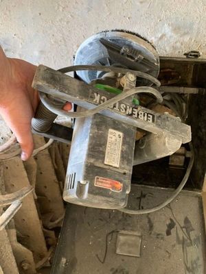 une personne qui utilise une scie circulaire pour couper un morceau de bois