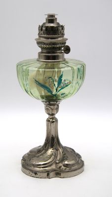 une lampe à huile ancienne en argent et verre vert sur fond blanc