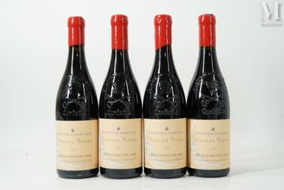 four bottles of red wine are lined up on a white surface