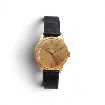 une image d'une montre-bracelet en or avec un bracelet en cuir noir