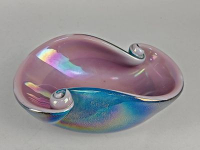 un saladier en verre violet et bleu posé sur une table blanche