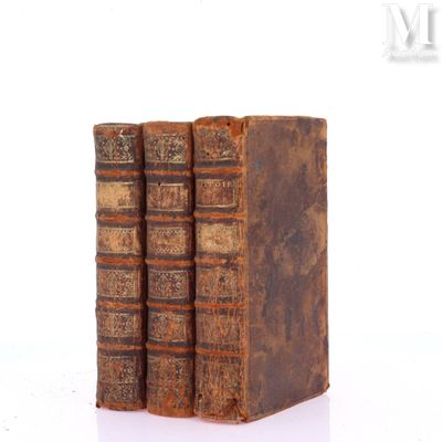 three old books sitting on top of each other on a white surface