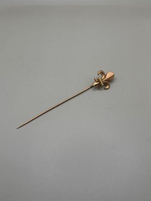 une broche en or ornée d'un cœur, posée sur une table