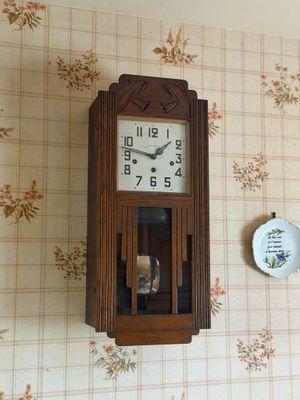 une horloge accrochée au mur, à côté d'une assiette accrochée au mur