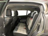 the back seats of a car with the door open and the driver ' s seat folded down