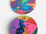 deux sous-verres ronds ornés de motifs colorés sur un fond blanc