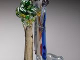 une figurine en verre représentant un homme et une femme sur un arbre