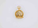 a close up of a gold pocket watch on a white surface