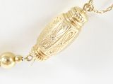 an image of a gold necklace with a gold bead on a chain