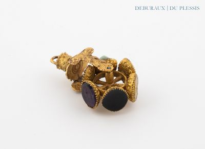 an image of a gold ring with a purple stone on it