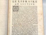 un livre ouvert posé sur une table, à côté d'une étiquette
