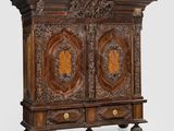 une vieille armoire en bois avec des sculptures et des gravures sur les portes