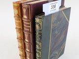 trois livres sont empilés sur une surface blanche