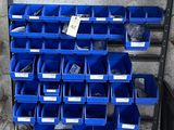 de nombreux bacs bleus empilés sur un support dans un garage
