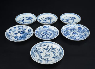 six assiettes bleues et blanches ornées de fleurs sur un fond noir