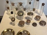 une table sur laquelle sont disposées de nombreuses bouteilles en verre et des couverts en argent