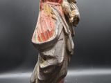une statue ancienne d'une femme tenant un bébé dans ses bras