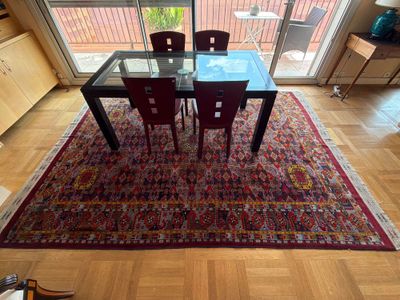 une table en verre avec quatre chaises et un tapis au sol
