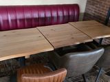 a table and chairs in a booth with a brick wall