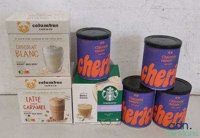 several boxes of coffee are sitting on a table next to a cup of coffee