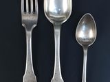 trois cuillères, une fourchette et une cuillère sur une table
