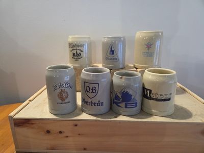 many different types of coffee mugs sitting on a wooden tray
