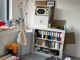 a room with a microwave, a microwave oven, and boxes on the floor