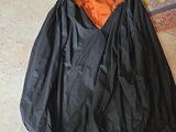 a black and orange bag sitting on the floor next to a pair of shoes