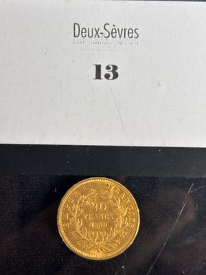 a close up of a gold coin on a black surface
