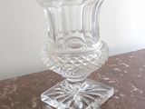 un vase en verre posé sur une table, elle-même posée sur une autre table
