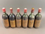 six bottles of wine are lined up in a row on a table