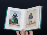 une personne tenant un livre ouvert sur lequel figurent des photos de personnes