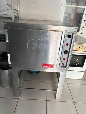 un four argenté installé dans une cuisine, à côté d'une cuisinière
