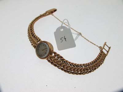 un bracelet en or sur lequel est fixée une montre, avec une étiquette de prix