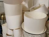 many cups and bowls on a shelf in a room