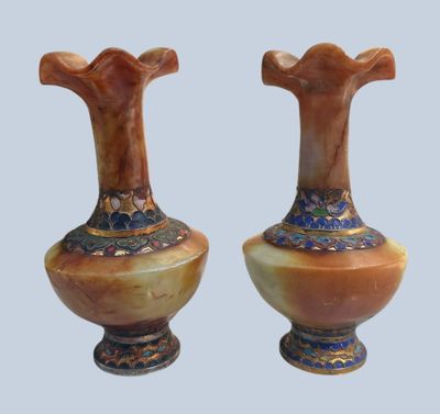 pair of vases sitting on top of each other on a blue surface
