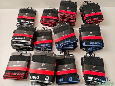 de nombreuses paires de chaussettes noires et rouges posées sur une table blanche