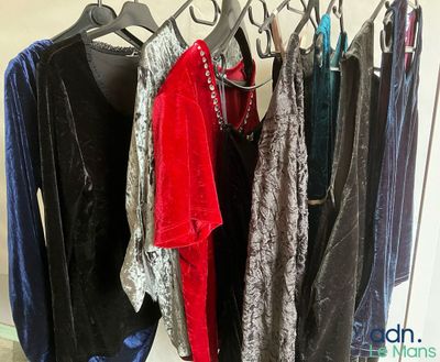 a lot of clothes hanging on a rack in a room