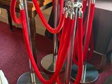a red rope and a silver pole on the floor