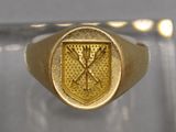 un gros plan d'une bague en or sur laquelle est gravé un blason
