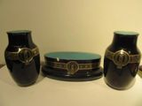 three vases sitting on a table with a plate on it