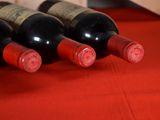 several bottles of wine are lined up on a red table