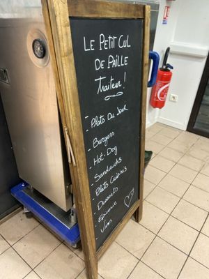 a chalk board with a menu written on it in front of a refrigerator