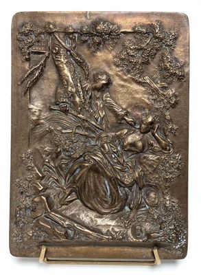 a bronze plaque depicting a woman and birds in a forest