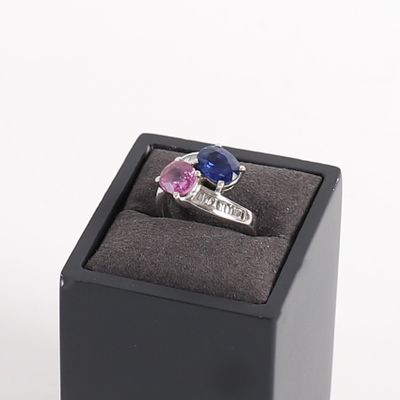 a ring in a black box with a pink and blue stone