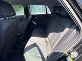 la banquette arrière d'une voiture, la portière ouverte et le siège conducteur rabattu