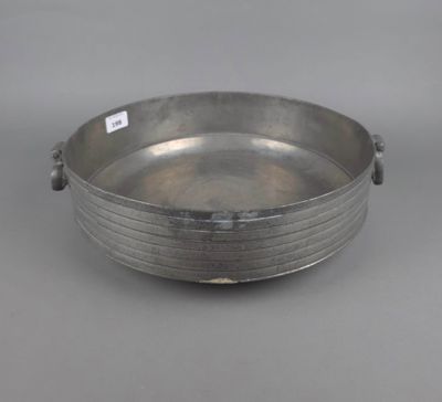 une assiette en argent avec une poignée, sur fond gris