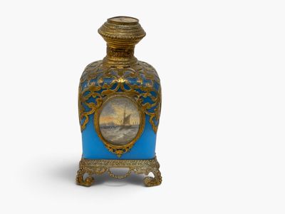 a blue and gold vase with a picture of a ship on it