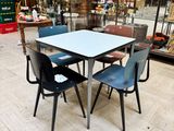 une table et des chaises dans une pièce où se trouve une vitrine