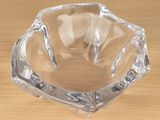 a clear glass ashtray on a wooden table